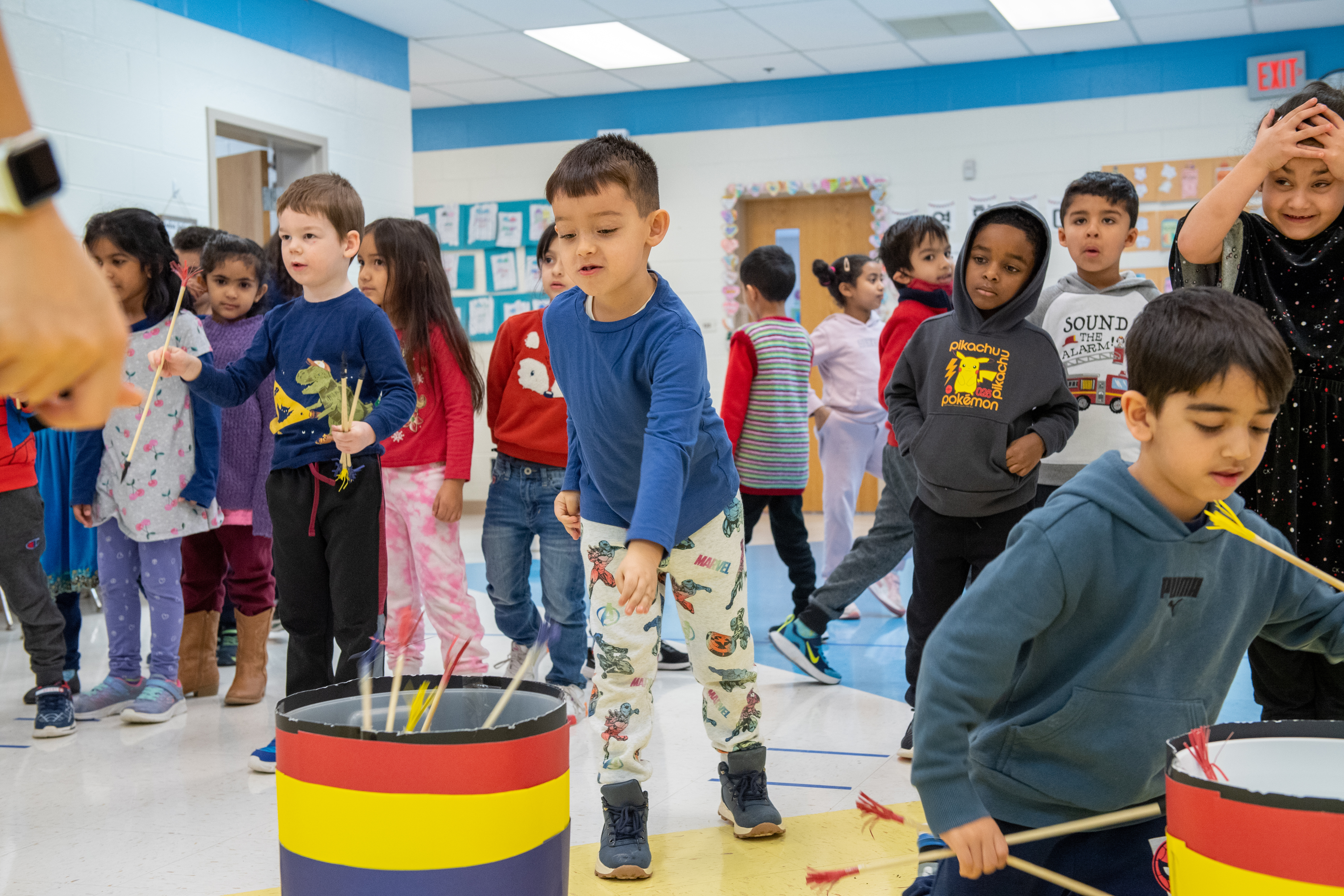 Kindergarten students at Powell ES play a game of tossing sticks into buckets at Lunar New Year festivities.
